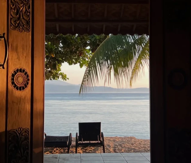 Tumbona ante la puerta de un apartamento en la playa en Bali.