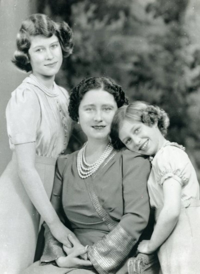 Una jovencísima Isabel (izquierda) con su madre, Elizabeth, y su hermana menor, Margarita.