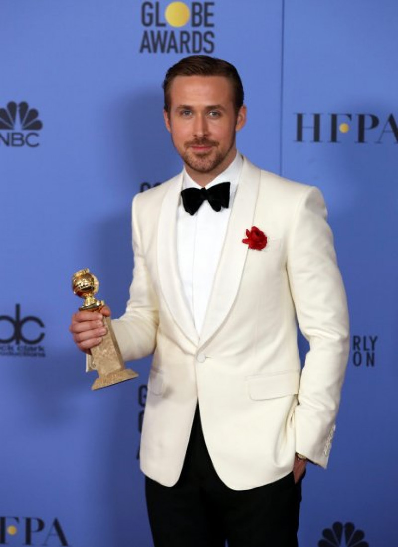 Ryan Gosling, muy elegante con smoking blanco, con su Globo de Oro.  