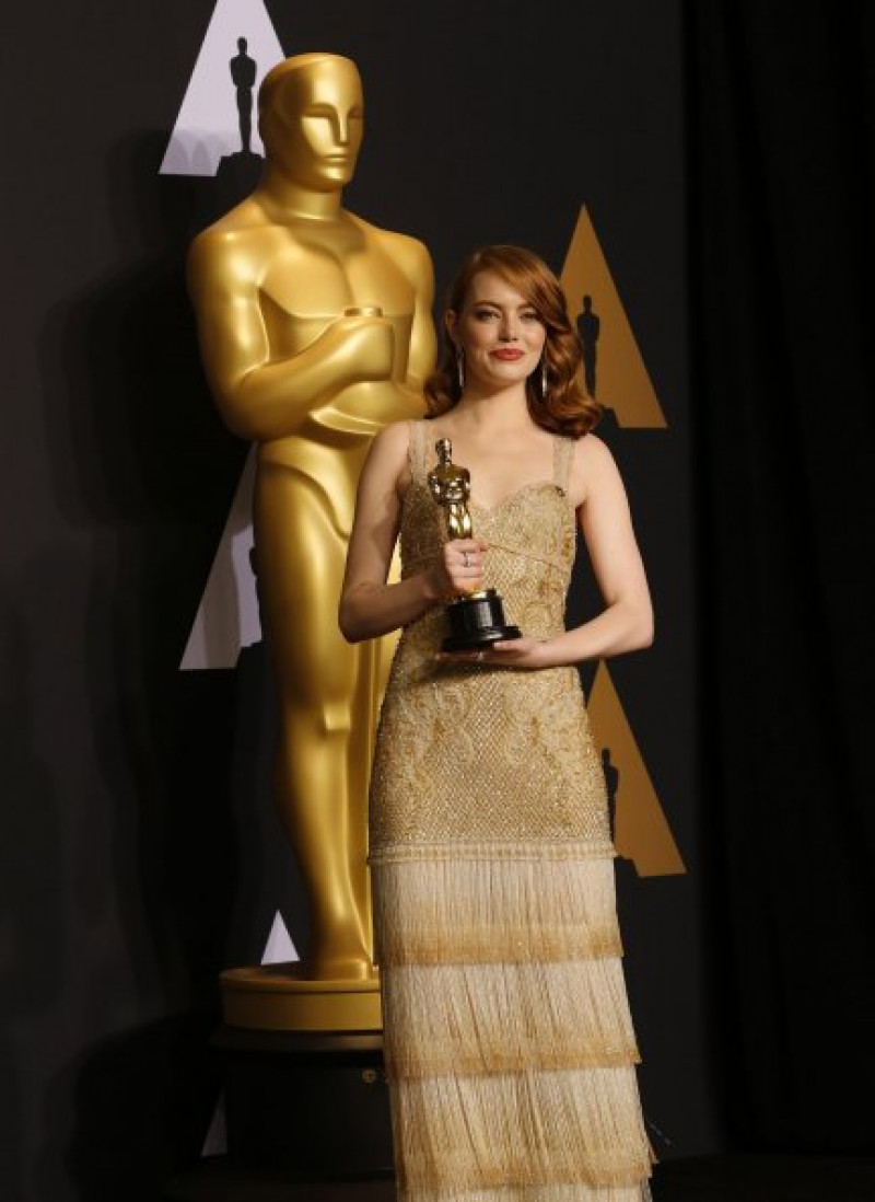 Emma sosteniendo la codiciada estatuilla dorada, que ha conseguido con sólo 28 años.