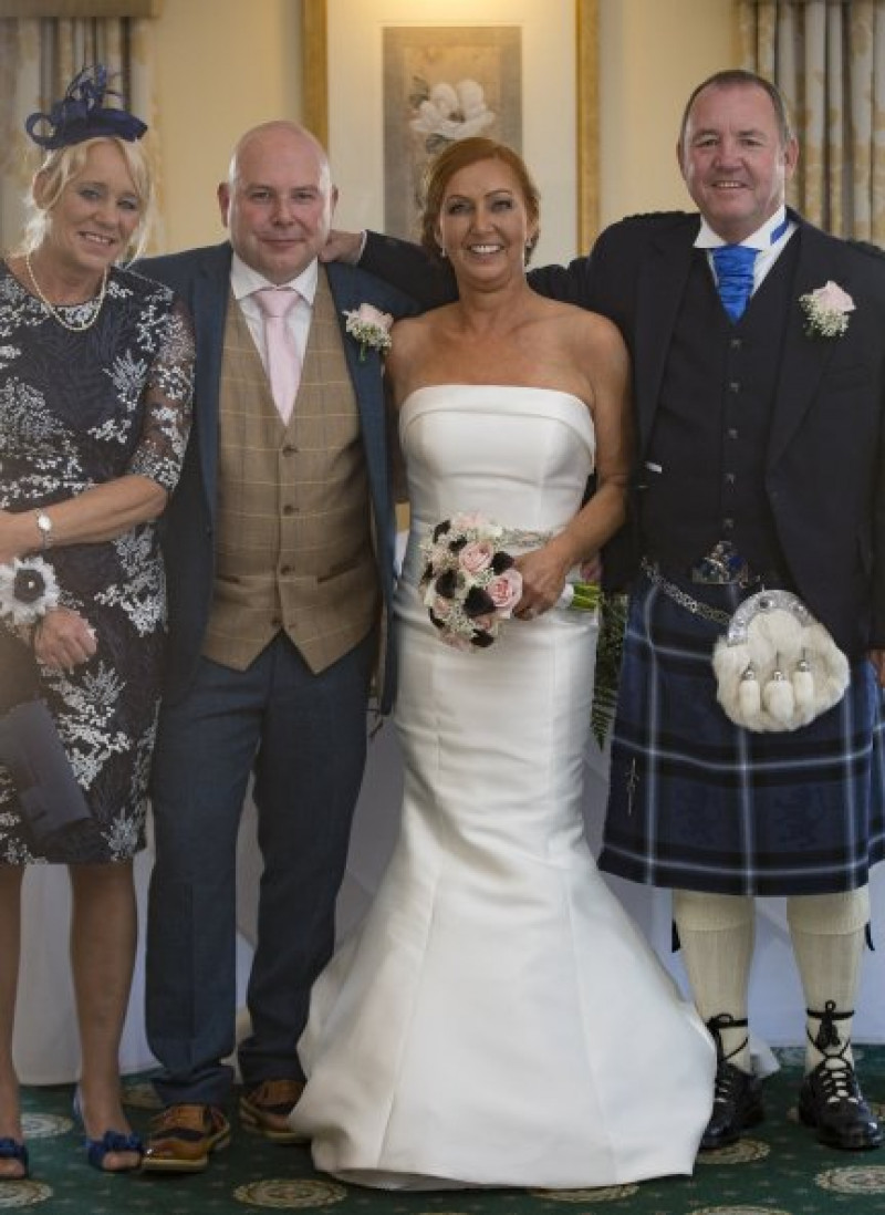 Lisa Simkin con su marido, Jim, el día de su boda con los padres de Rhona, Jane y John Moffat.