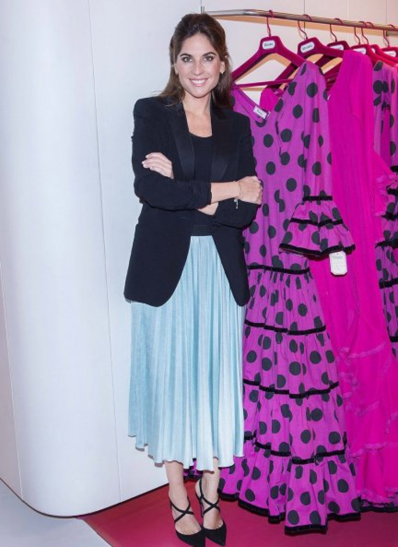 Lourdes Montes posando junto a una de sus colecciones de vestidos de faralaes.