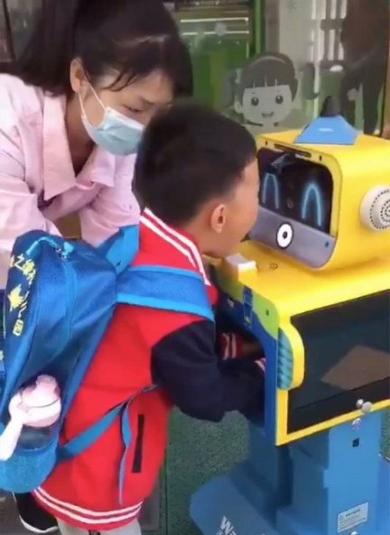 Niño chino mostrando parte del protocolo para entrar en la escuela.