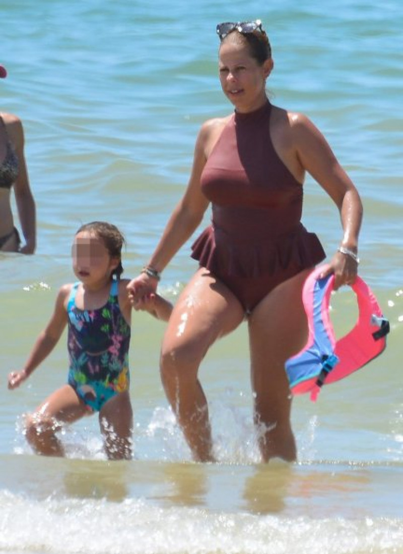 Madre e hija salen del agua tras refrescarse en el mar.