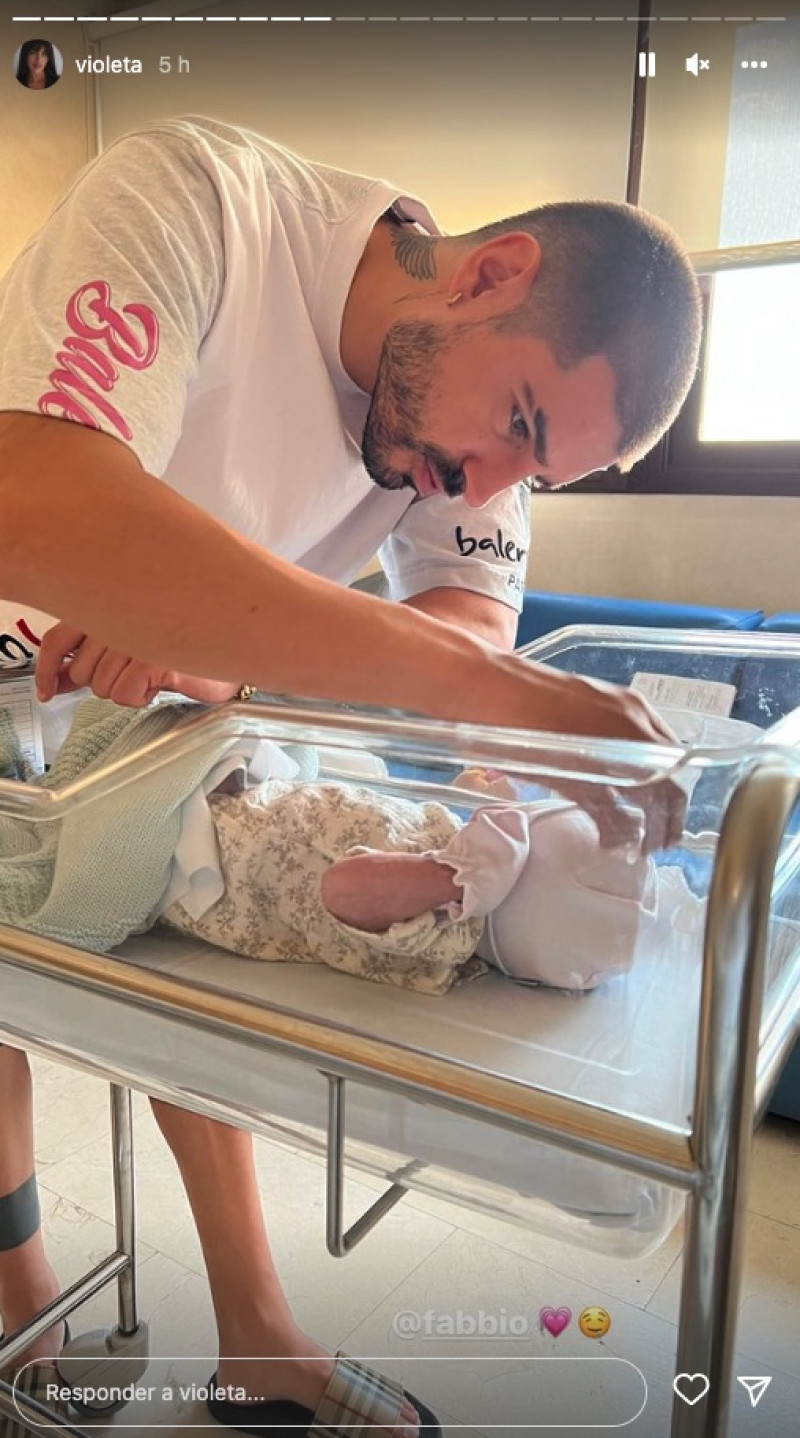 Fabio, papá orgulloso, acariciando a su hija recién nacida