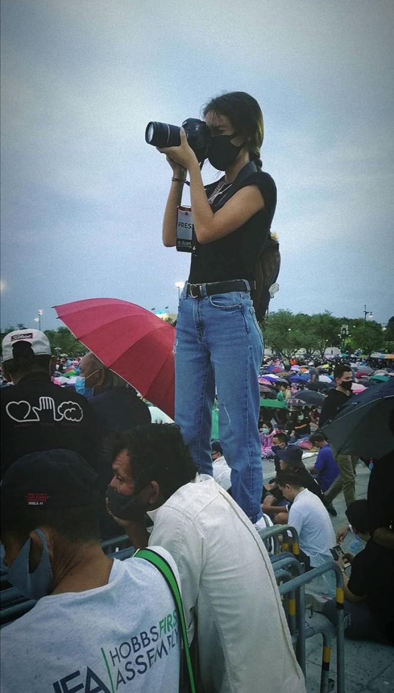 Laura sacando fotos desde una valla en Tailandia