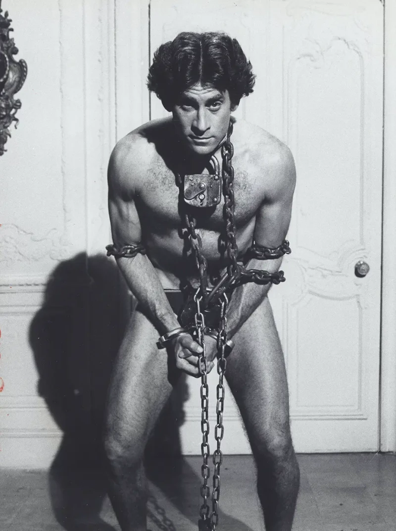 El actor Paul Michael Glaser caracterizado y atado de manos y pies con cadenas como el escapista Harry Houdini.