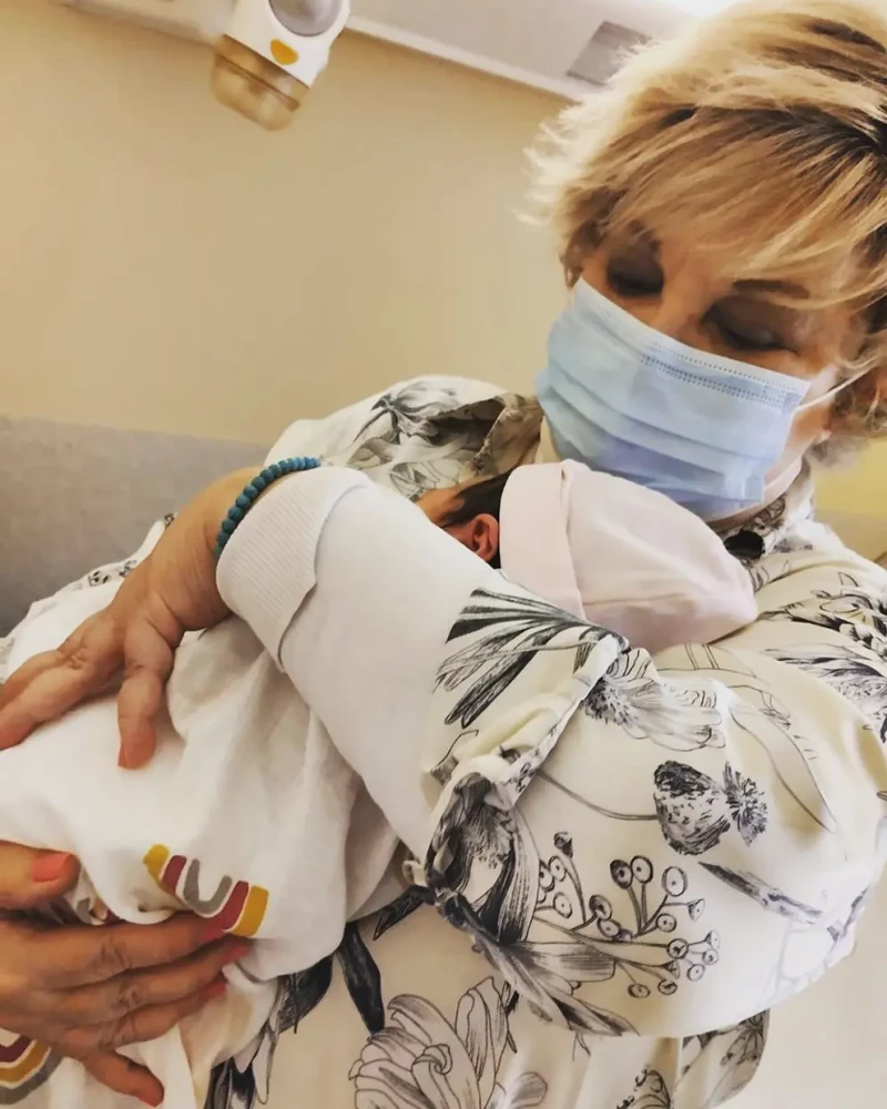 Karina con su nieta recién nacida en brazos.