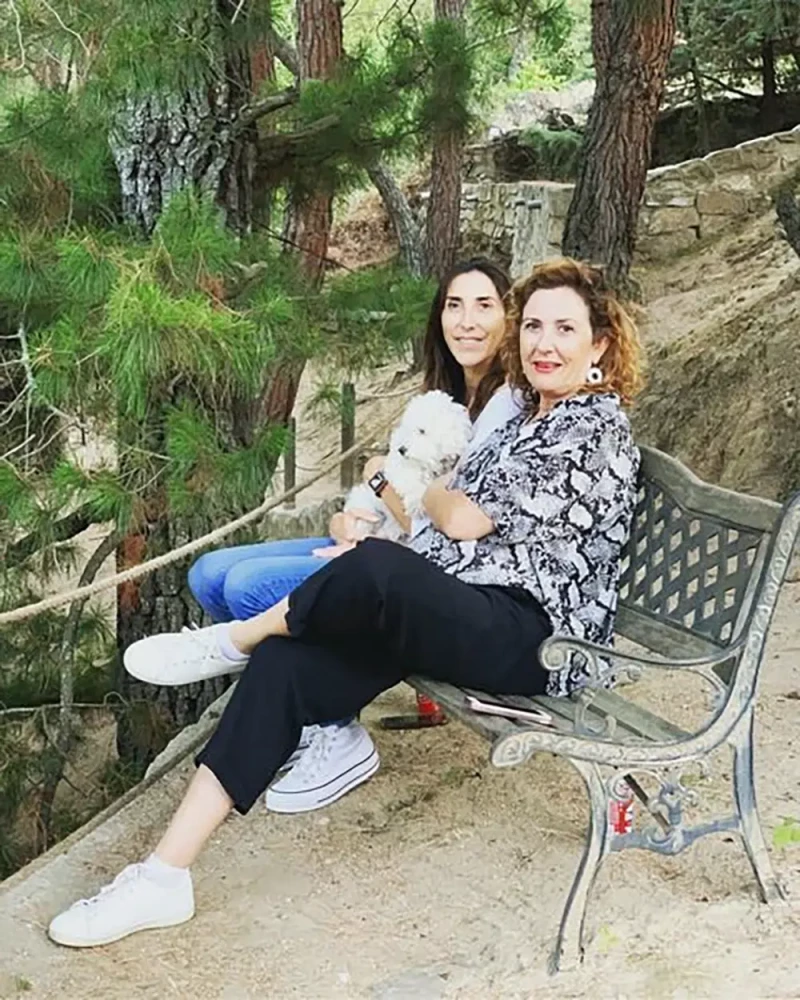 Paz Padilla con su perro y su hermana Ana sentadas en un parque