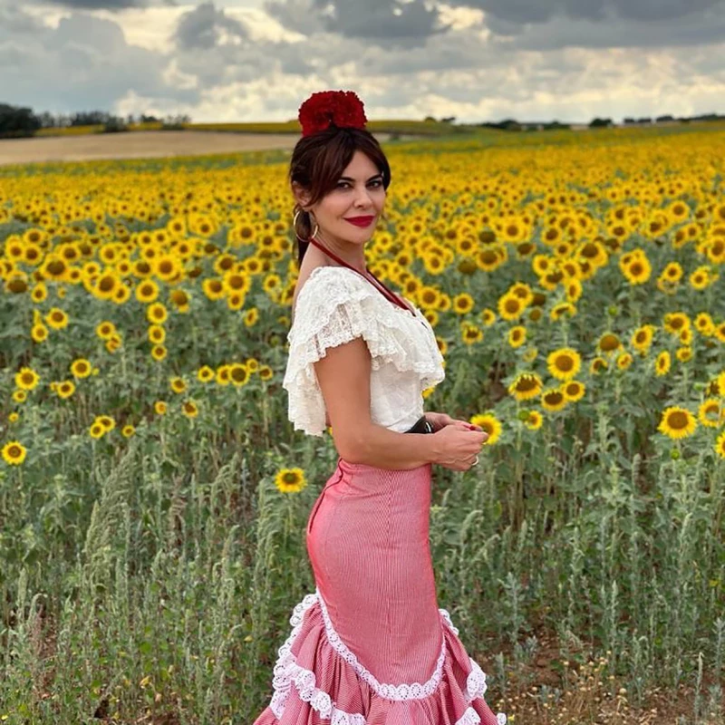 María José Suárez posando frente a un campo de girasoles.