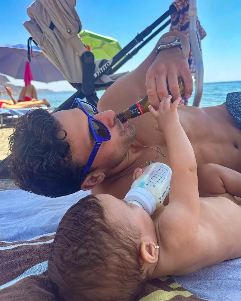 Jaime Astrain tomando una foto graciosa en la playa junto a su bebé.