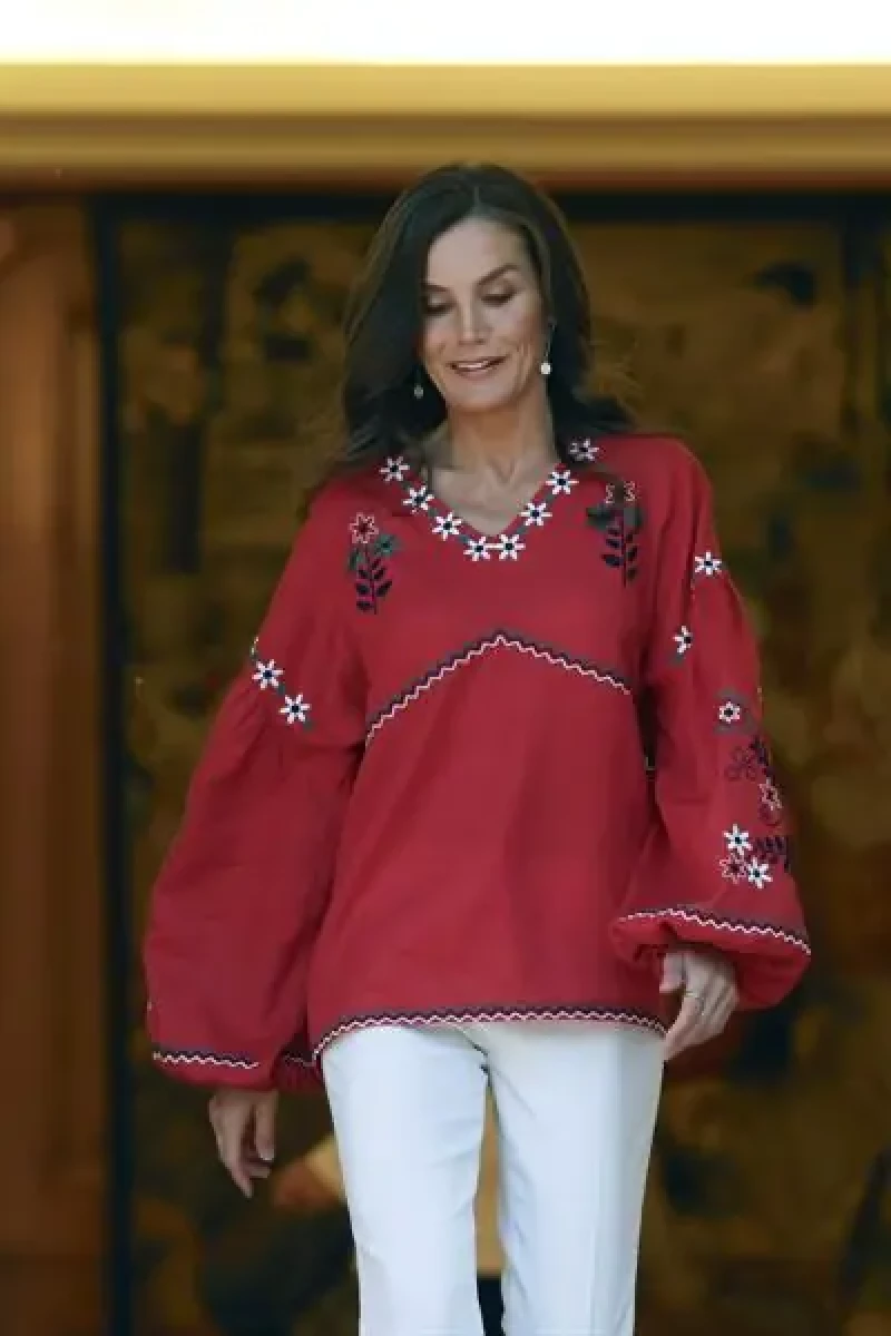 La reina Letizia con una camisa étnica y pantalón blanco