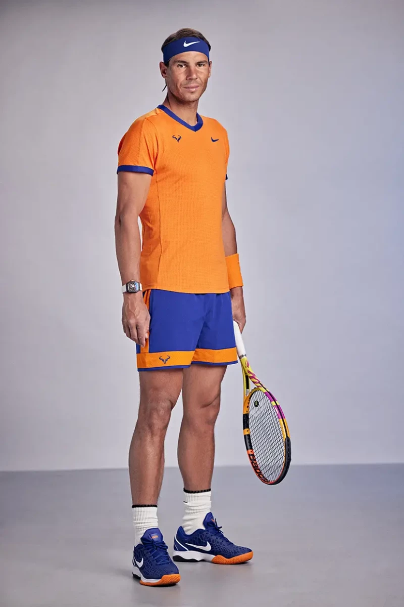 Rafa Nadal posando con una raquesta de tenis y vestido de tenista.