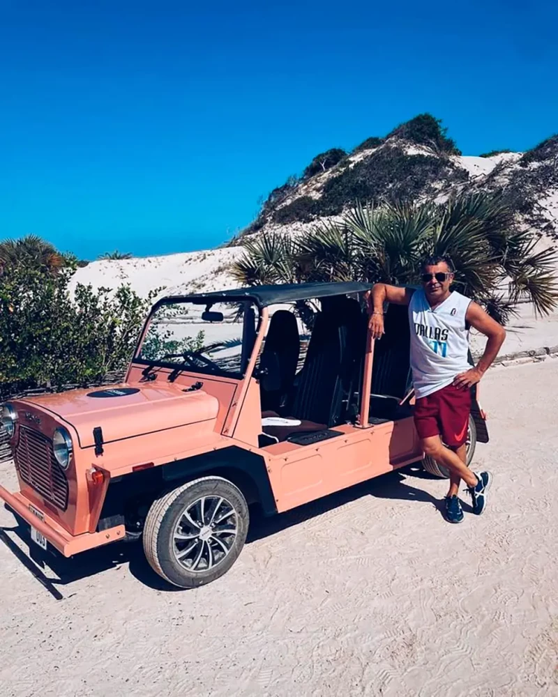 Jorge Javier Vázquez posando junto a un coche en un lugar de playa.