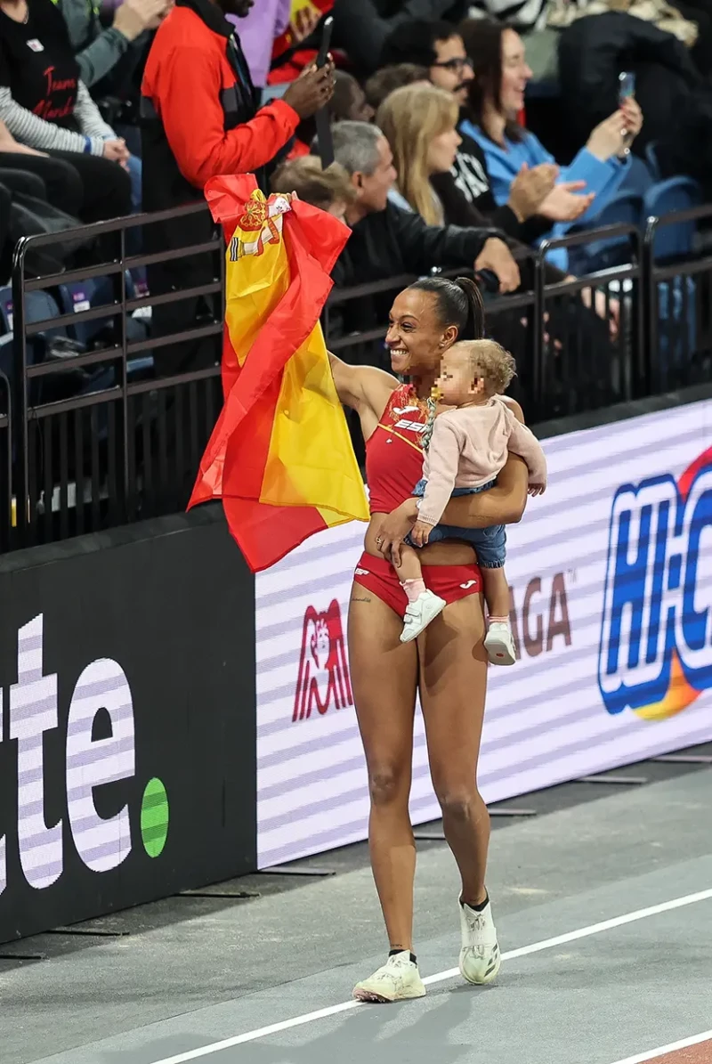 Ana Peleteiro paseando con su bebé en brazos y la bandera de España.