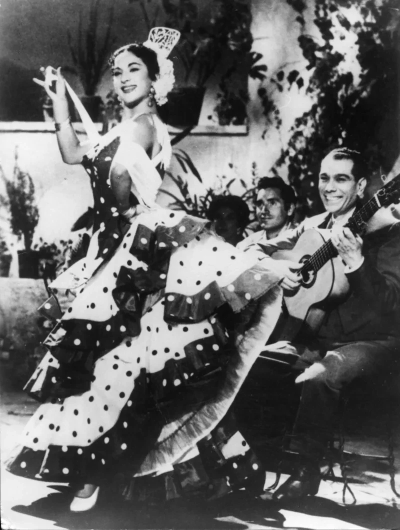 Lola Flores cantando y bailando con un traje de flamenca