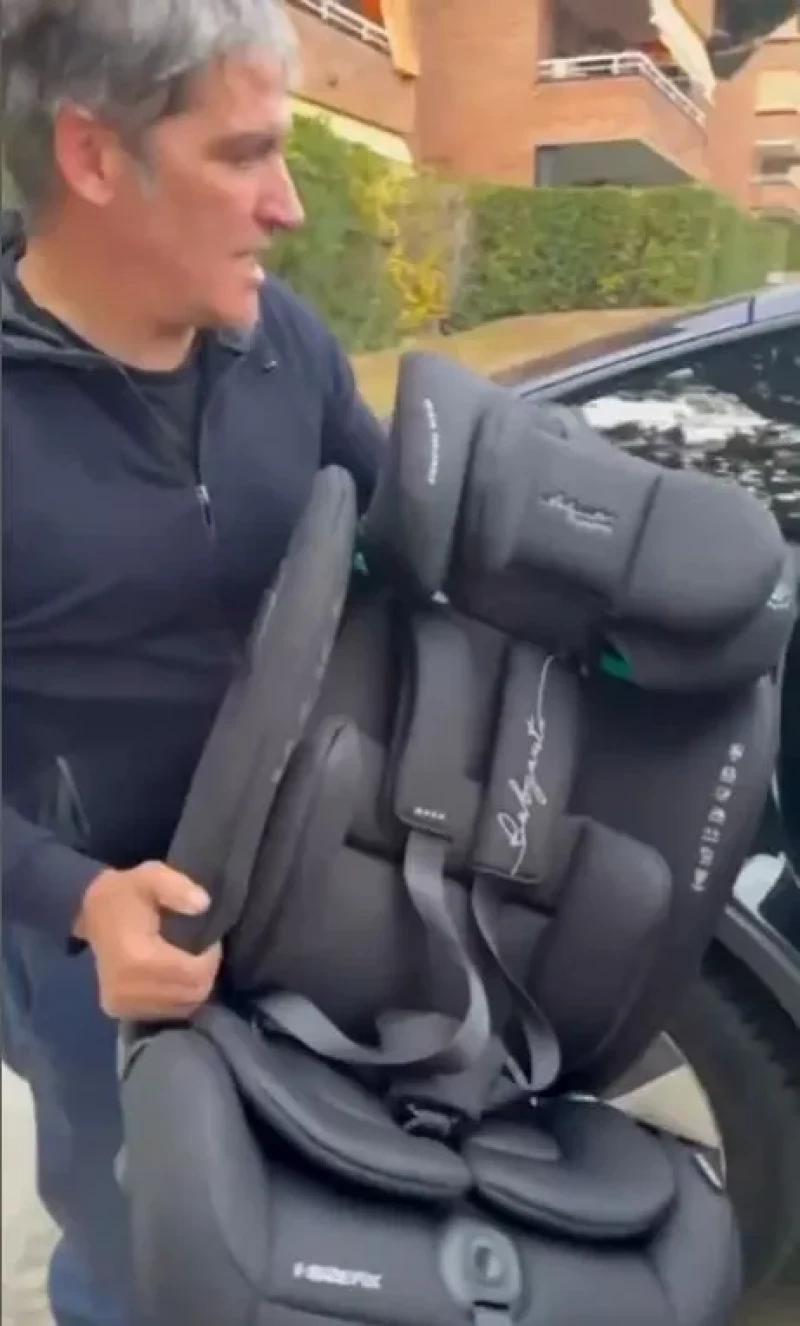 Gustavo González coloca la sillita del coche de su hija.