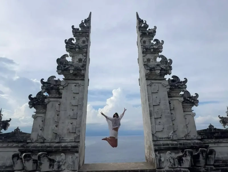 Monica Carrillo saltando junto a un monumento en Bali