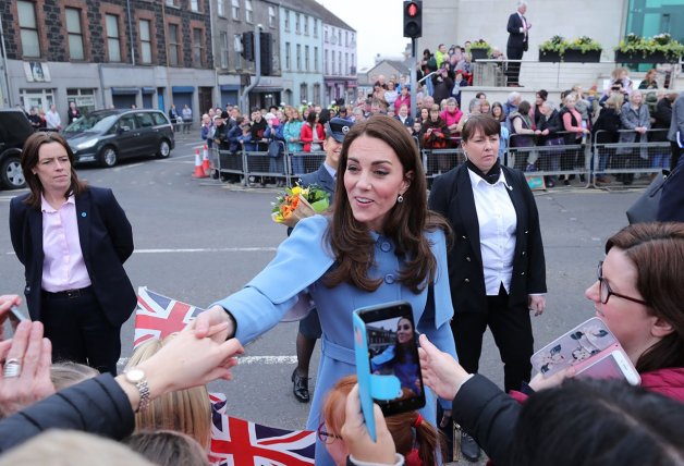 A la izquierda, la duquesa saludando a gente durante uno de sus viajes oficiales.