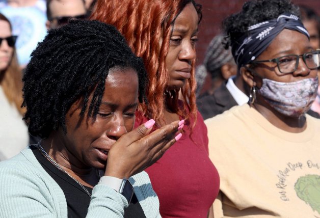 Mujeres que escaparon de la matanza llorando a las afueras del supermercado.