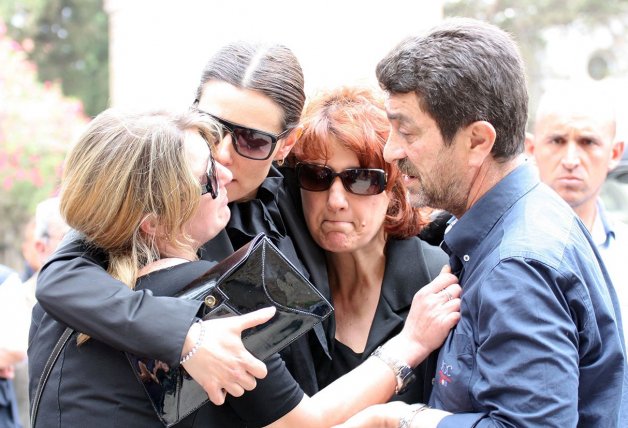  Raquel, abrazada a la hermana y los padres de Mario Biondo durante el entierro del cámara italiano.