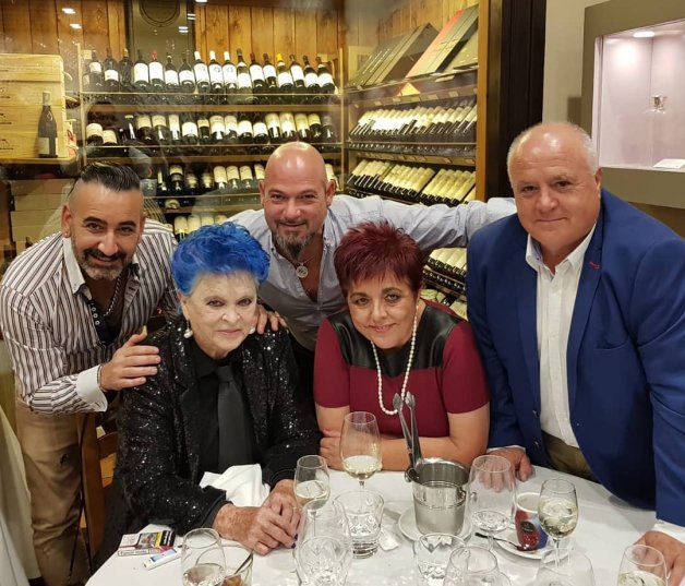 Lucía y su cuidadora, en un restaurante con amigos.