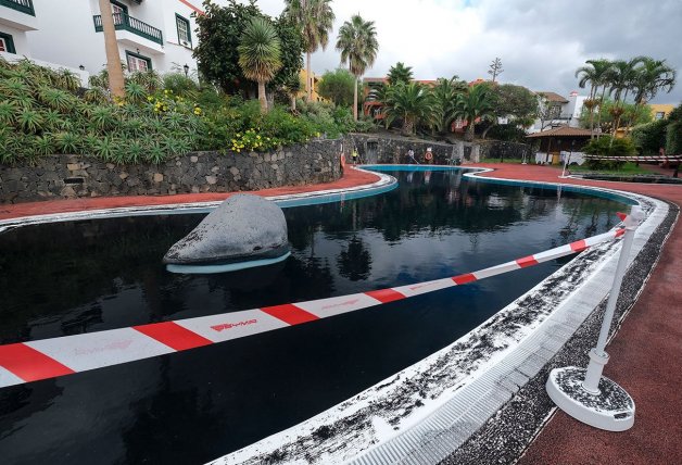 Una piscina teñida de negro por la ceniza.