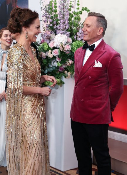 Kate Middleton charla animadamente con Daniel Craig, con americana de terciopelo fucsia.