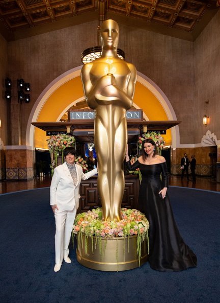 Diane Warren y Laura Pausini, nominadas por la mejor canción, posan con un Oscar gigante. Pausini deslumbró con su vestido de Valentino.