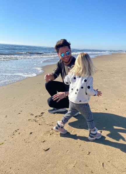 Padre e hija divirtiéndose en la playa.