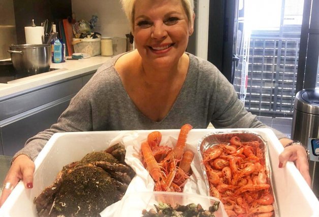 Terelu, posando con una bandeja de marisco en su cocina.