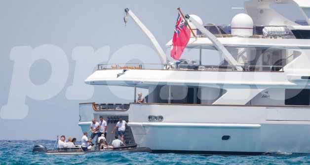 La tripulación ayuda a la familia a subir a bordo, bajo la atenta mirada de Douglas.