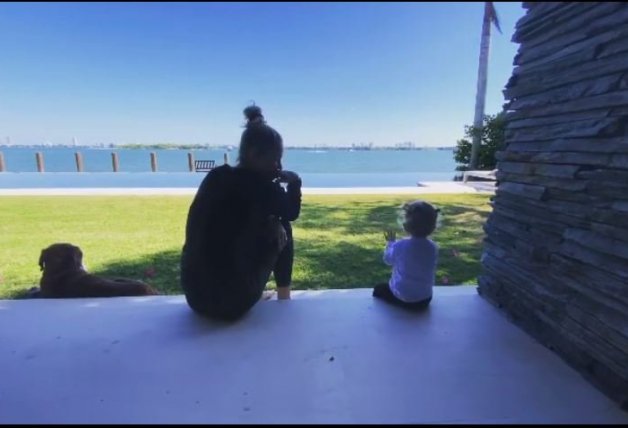 Anna, en el maravilloso jardín de su casa, mirando al mar con una de sus hijas.