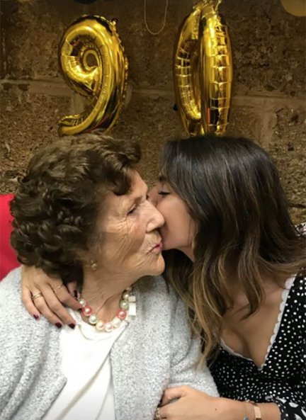 Abuela y nieta dándose un beso. 