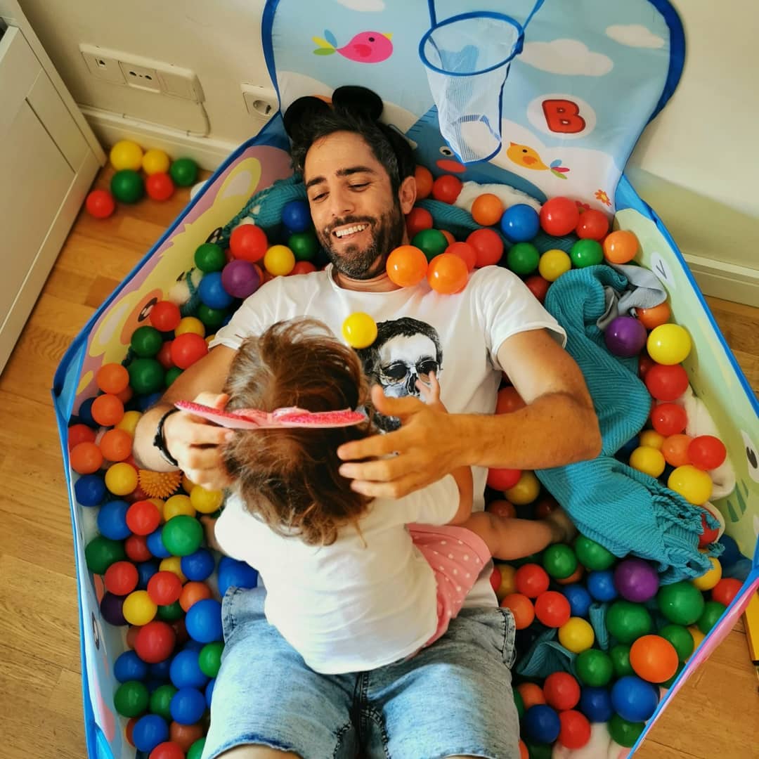 Padre e hija, disfrutando en la piscina de bolas.