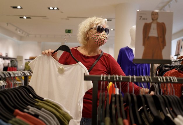 Una mujer comprando ropa en un pequeño comercio de Canarias.