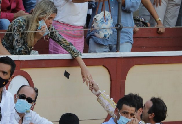 Enrique Ponce y Ana Soria se dan la mano. En la de él se puede apreciar el vendaje aplicado tras la cogida.