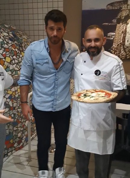 Can Yaman posa junto al cocinero de una pizzería en Milán.