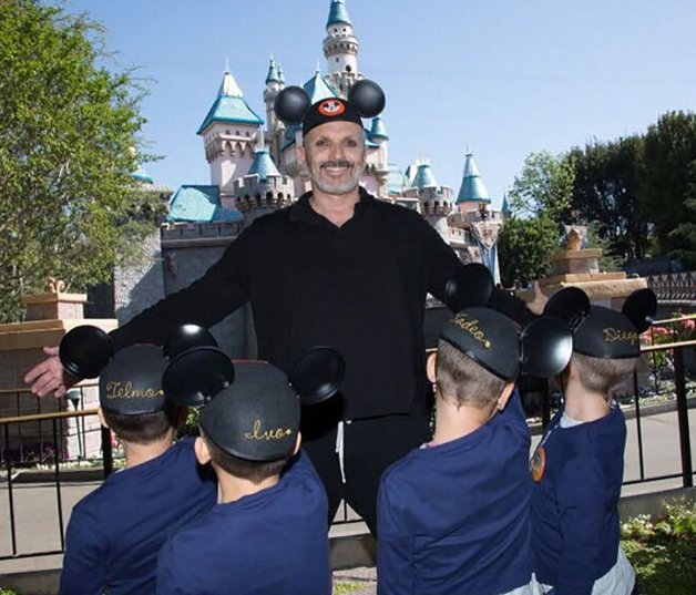 Miguel Bosé posando con los cuatro niños en un parque de atracciones.