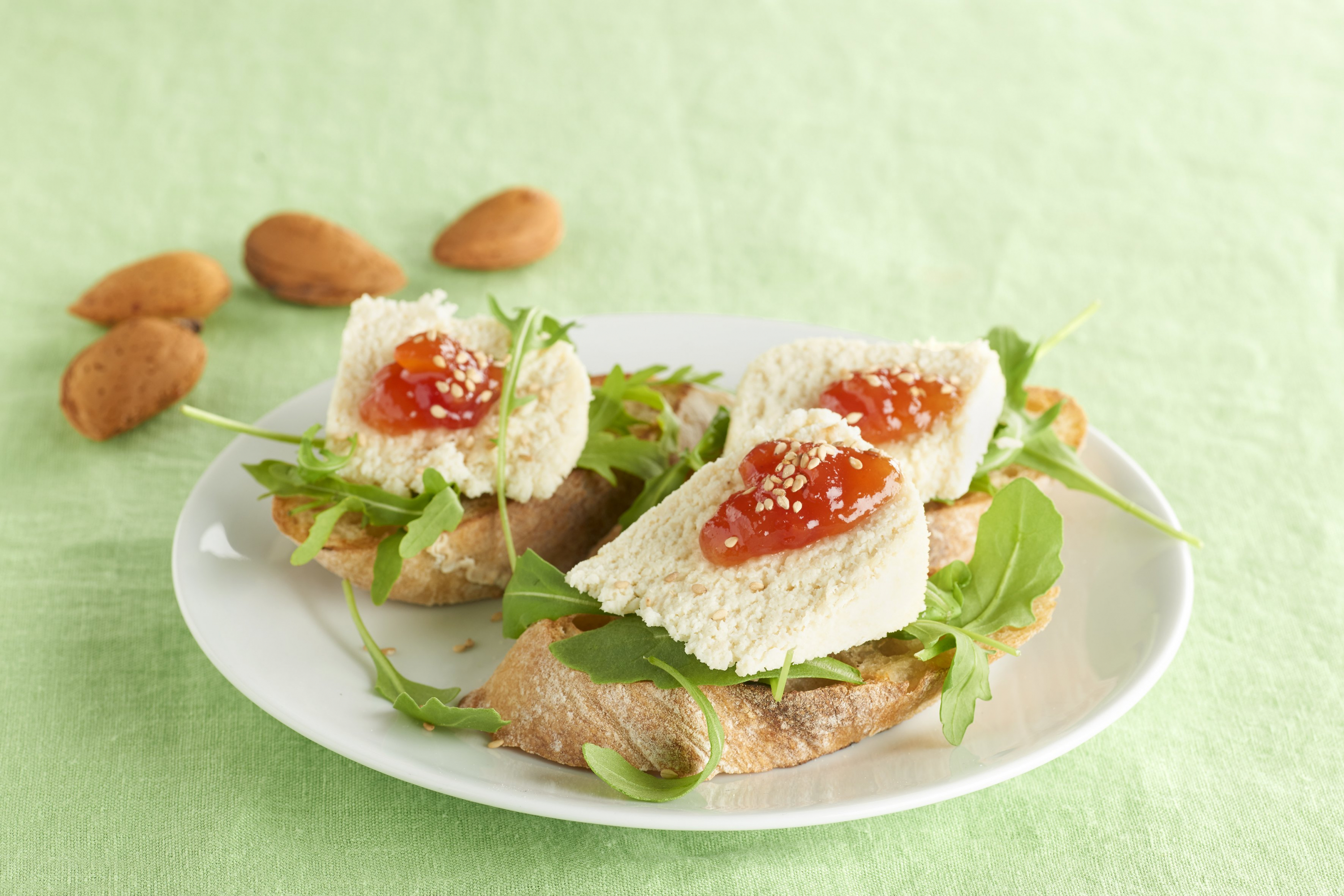 Tostadas con queso de almendras y mermelada de tomate.