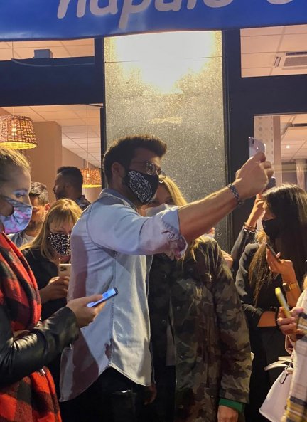 Can Yaman haciéndose una foto con una de sus fans.