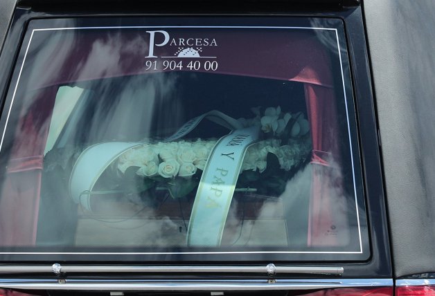 El coche fúnebre en el que viajaban los restos mortales de Álex, con una corona de “papá y mamá”.