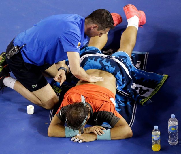 Rafa es atendido en pista por una lesión de espalda en el 2014.