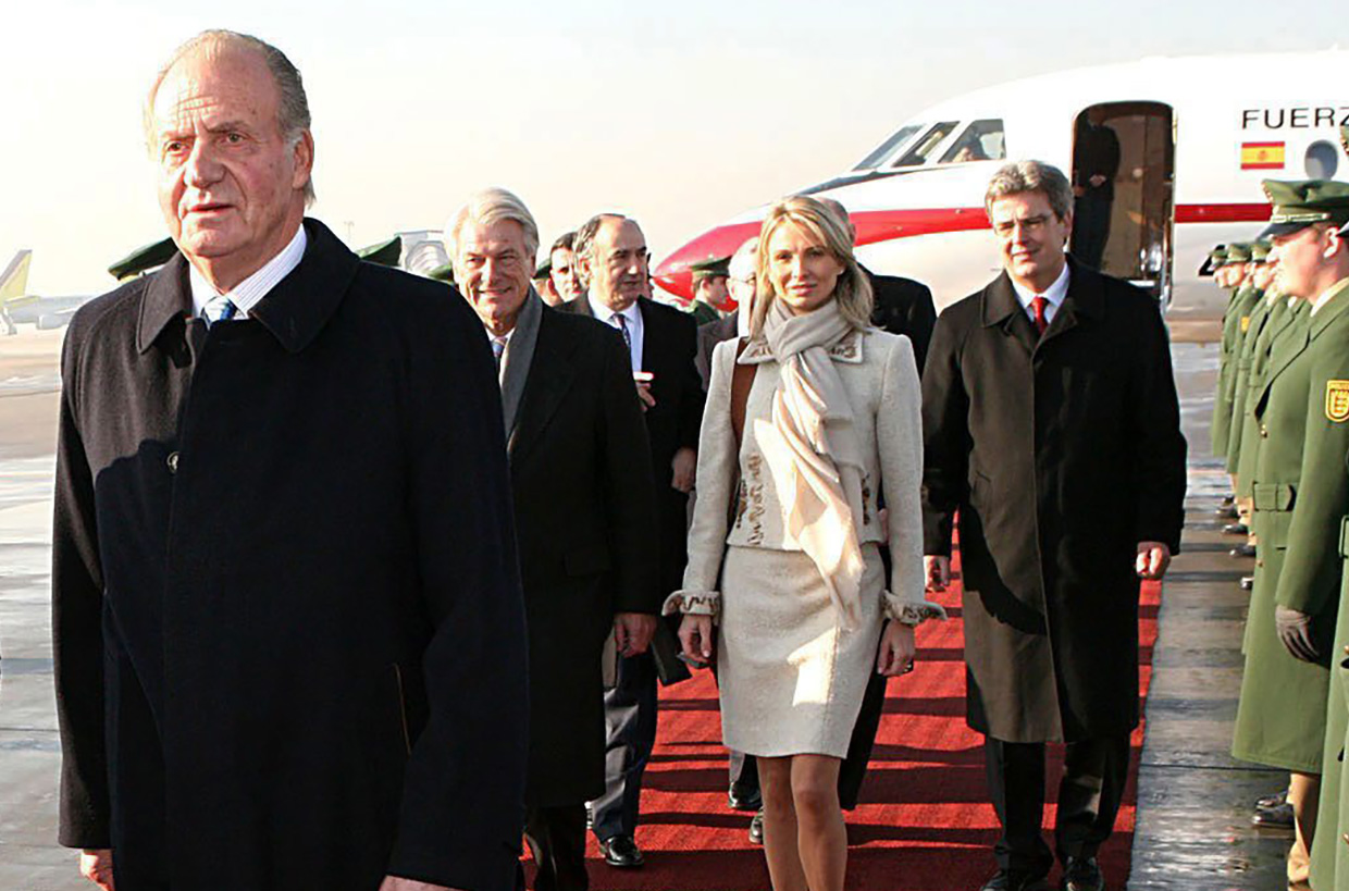 Juan Carlos seguido por Corinna después de bajar de un avión en un viaje