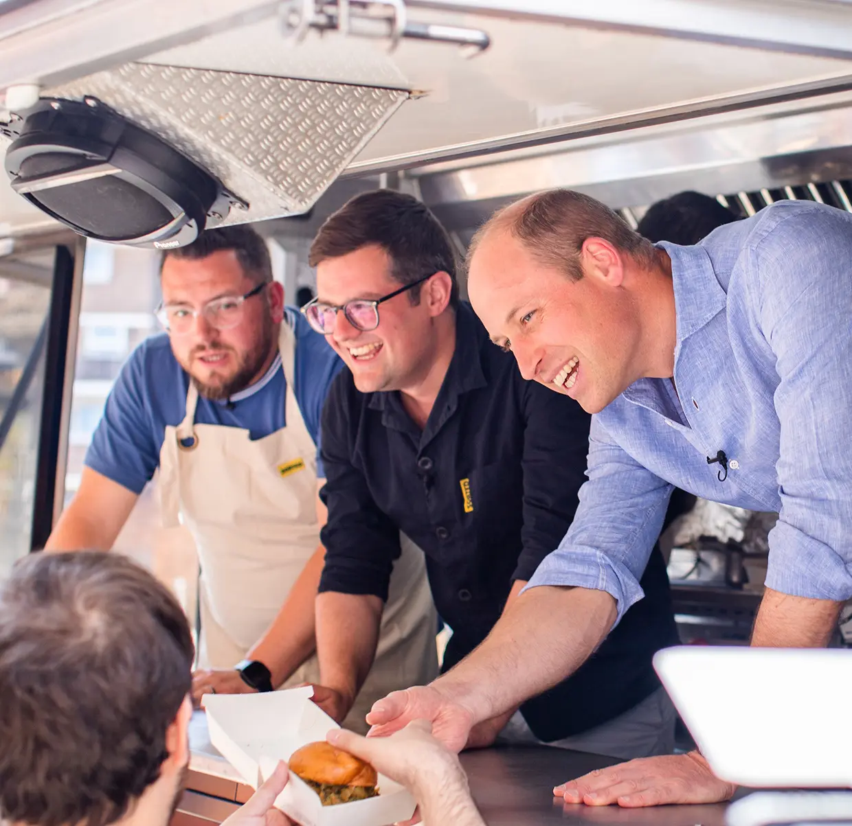 Guillermo sirviendo hamburguesas en un food truck.