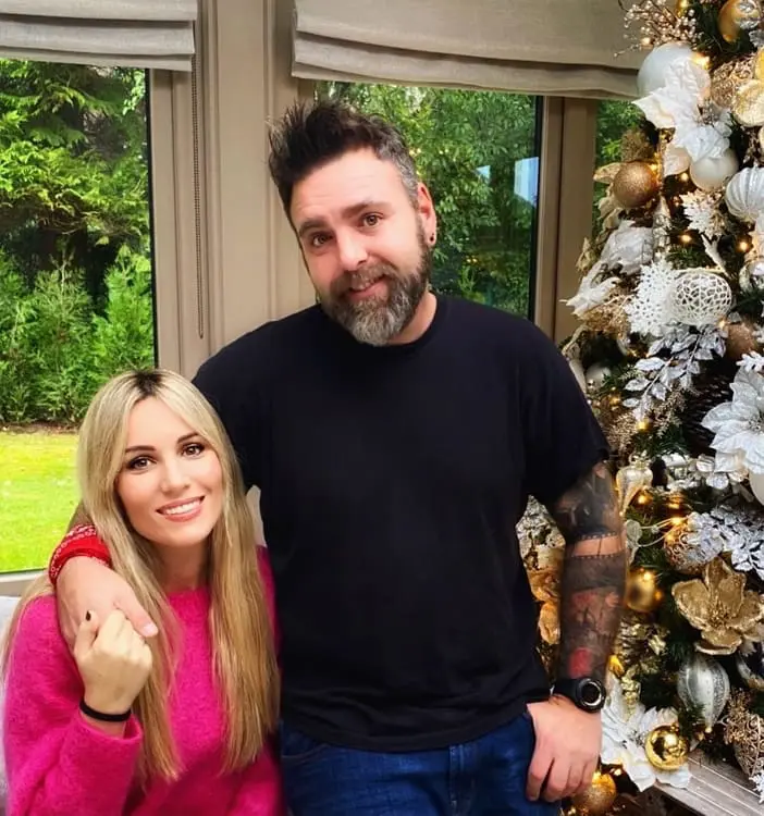 Edurne, feliz junto a su hermano, posando frente al árbol de Navidad.