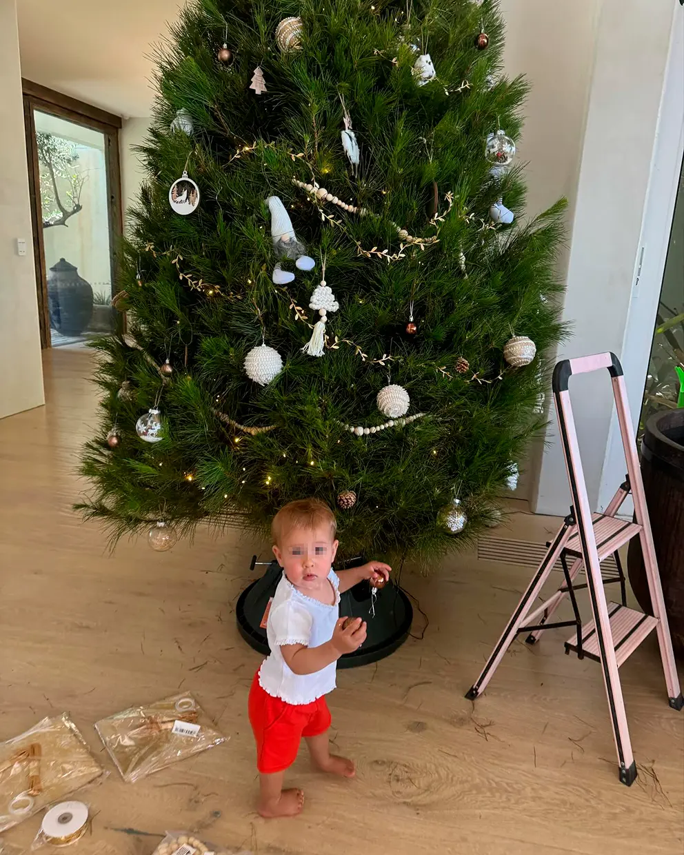 Uno de los hijos de Elsa Pataku decorando el árbol de Navidad en su casa