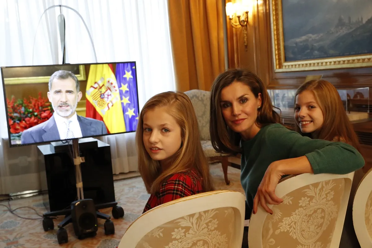Letizia y sus hijas viendo el mensaje del rey.