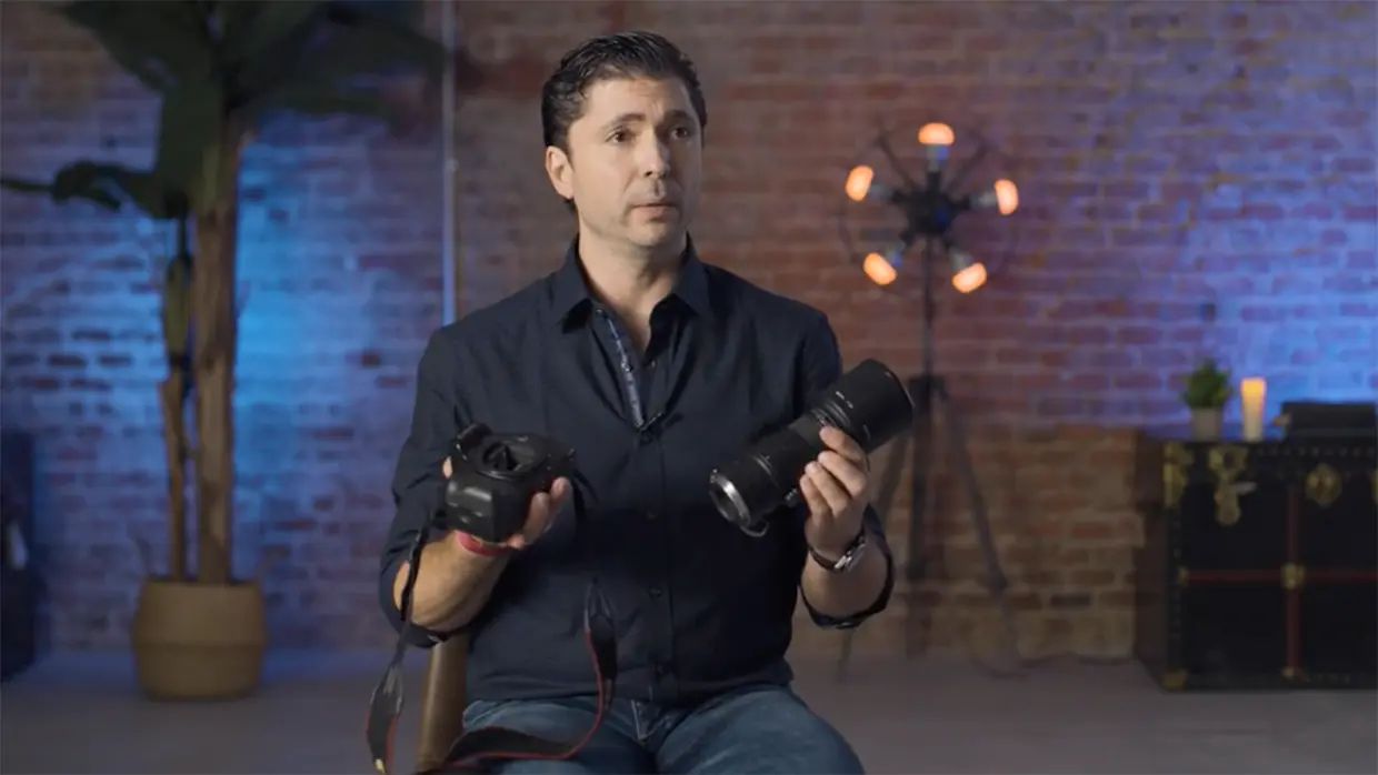 Ángel Cristo Jr con una cámara y un objetivo fotográficos durante una entrevista.