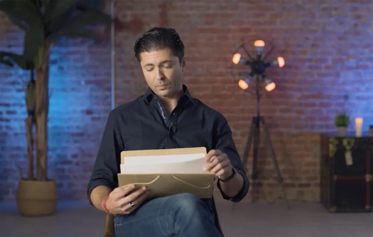 Ángel Cristo Jr mirando una carpeta con documentos durante la entrevista